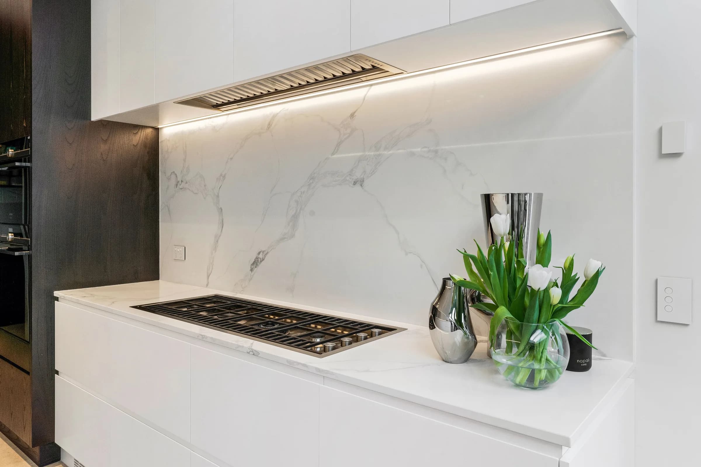 White kitchen detail with tulips and induction cooktop