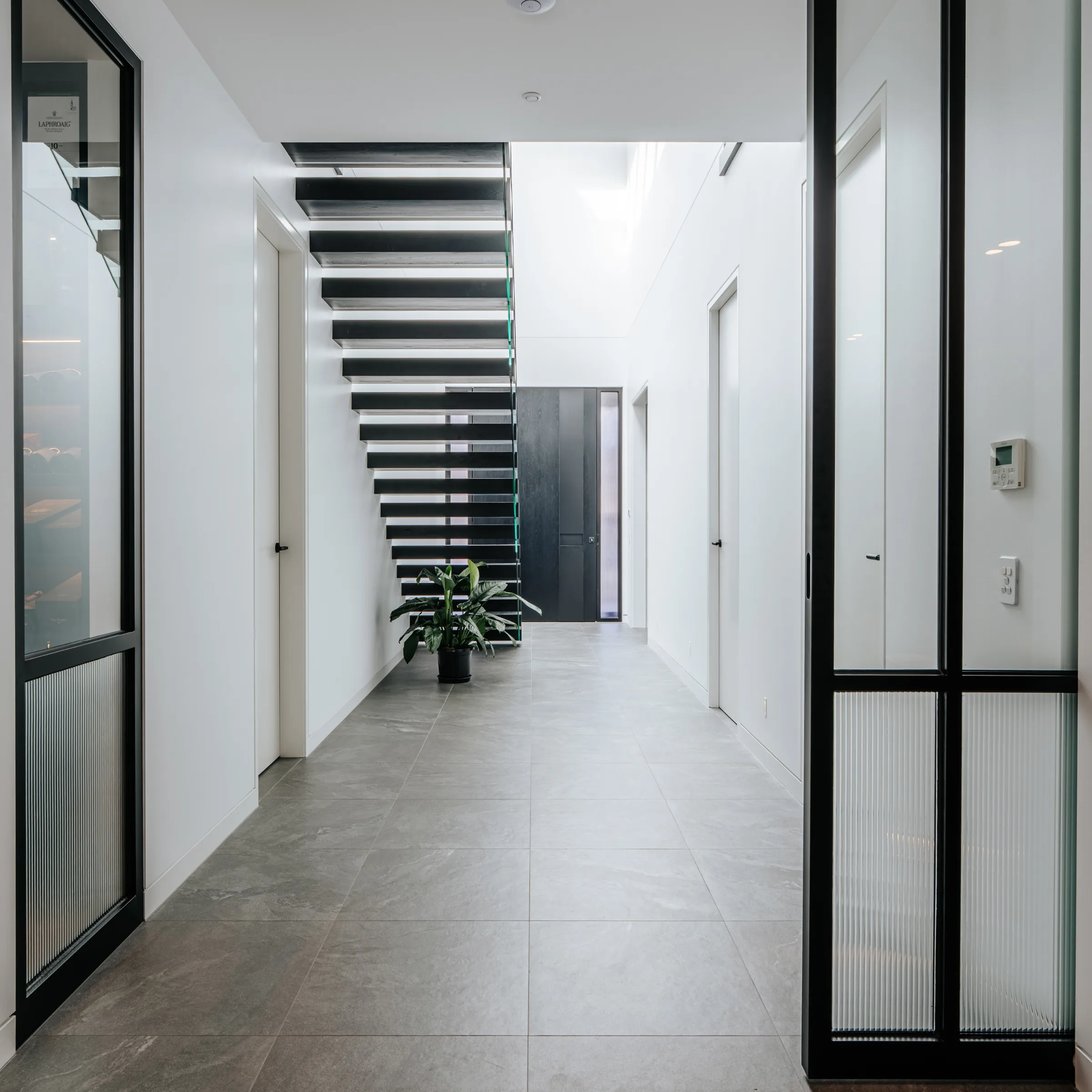 Hallway with black steel glazing and stair beyond