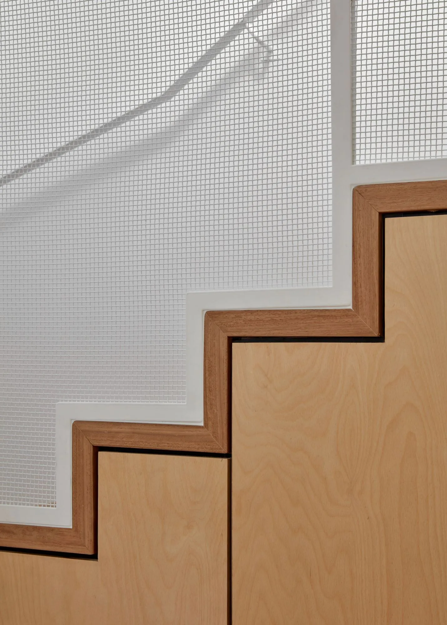 Plywood stair landing detail with black steel handrail